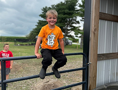 Carissa Bryant’s son sitting on a farm gate