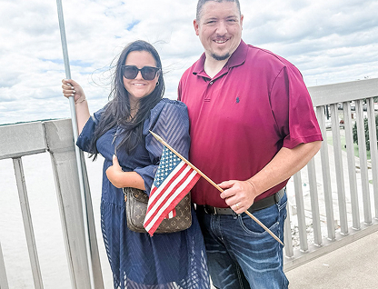 Carissa Bryant and her husband holding an American Flag